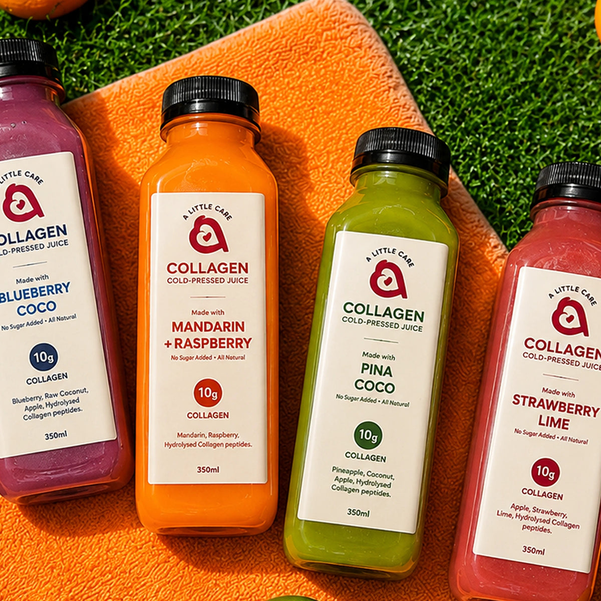 Four bottles of Collagen flavored juice arranged on an orange towel over green grass, with oranges around them. The bottles contain purple, orange, green, and pink juices and have white labels with red and blue text.